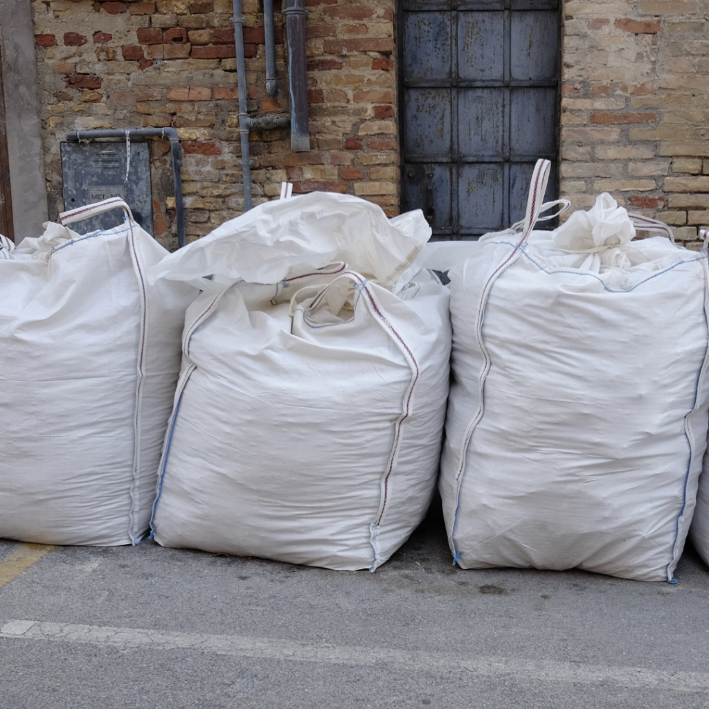Big-bags remplis de gravats devant une maison